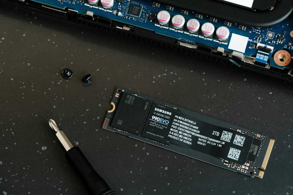 Samsung 990 EVO SSD on a table with screwdriver and screws